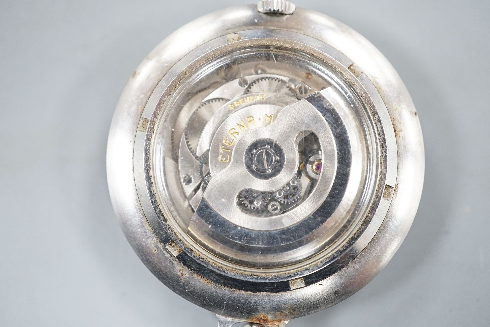 A base metal cased Eterna-matic manual wind dress pocket watch, with date aperture, on a metal chain.